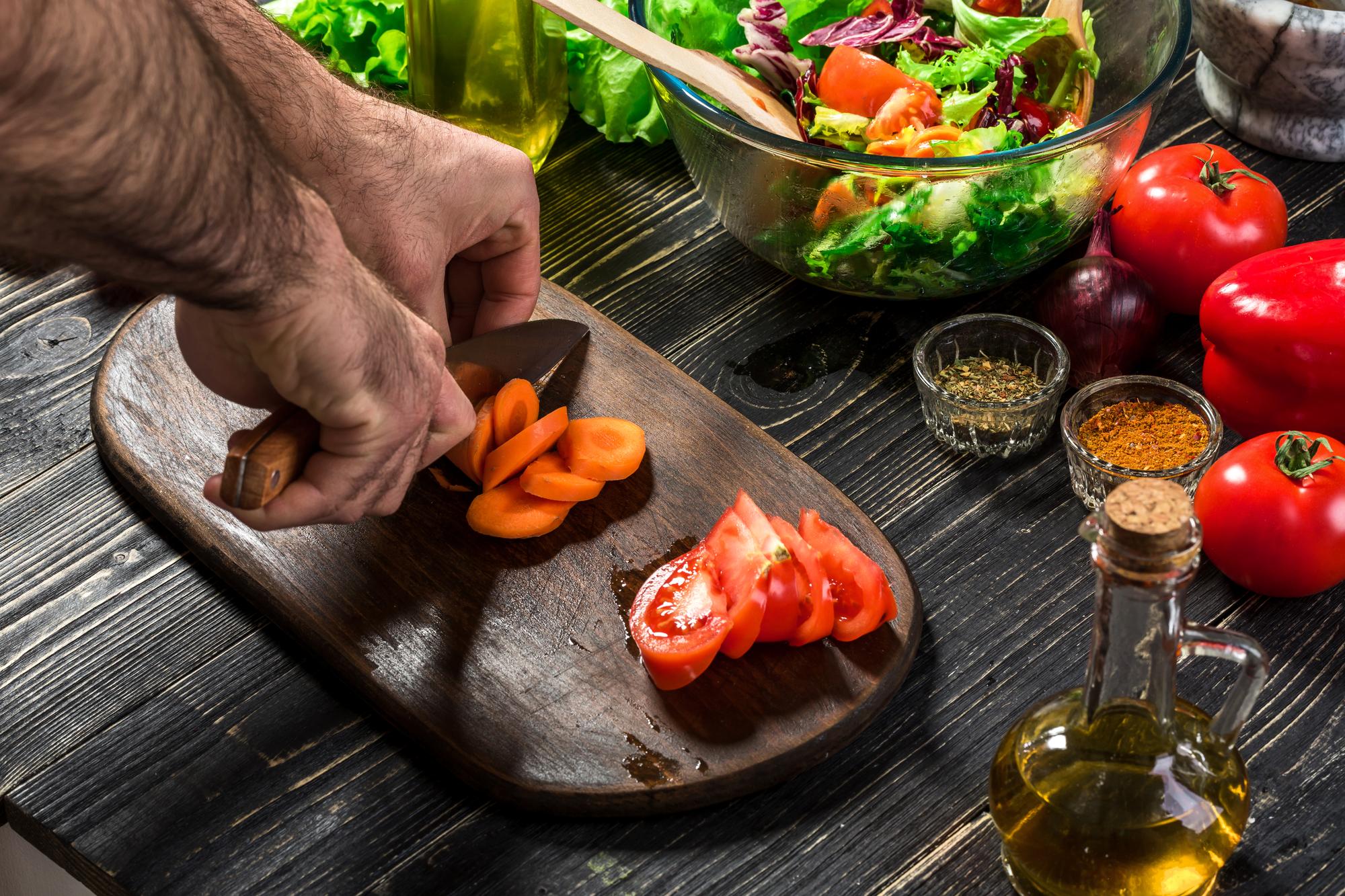chef preparing seasonal produce on wooden board